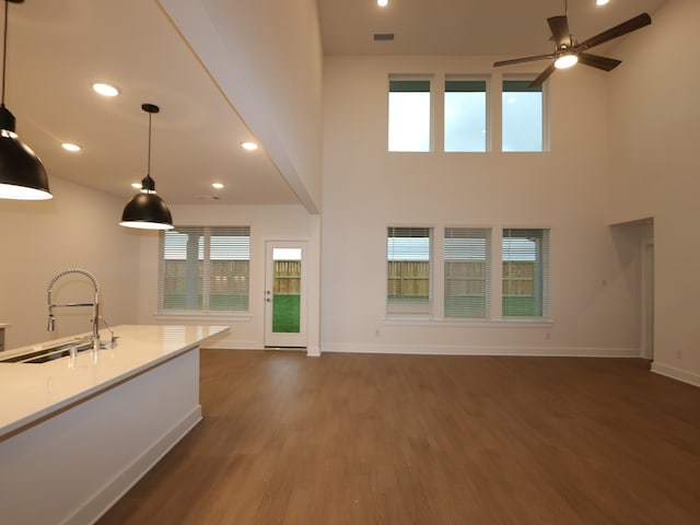 8515 Pier Cove Dr, Cypress, TX 77433 - unfurnished living room featuring dark wood-type flooring, ceiling fan, a towering ceiling, and recessed lighting