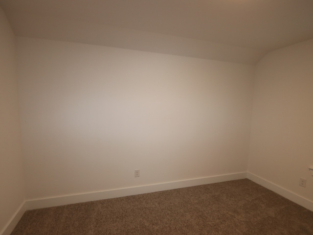 8515 Pier Cove Dr, Cypress, TX 77433 - spare room featuring dark colored carpet and lofted ceiling