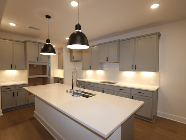 8515 Pier Cove Dr, Cypress, TX 77433 - kitchen with gray cabinets, dark wood-style floors, decorative backsplash, a center island with sink, and recessed lighting