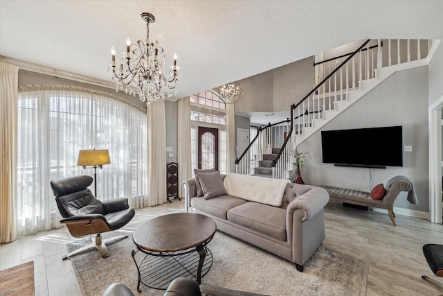 living room with an inviting chandelier, light hardwood / wood-style floors, and a textured ceiling