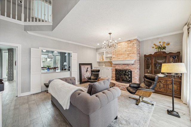 living room with ornamental molding, a brick fireplace, an inviting chandelier, and light hardwood / wood-style floors