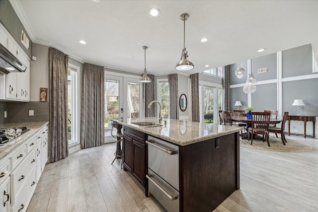 kitchen featuring light stone countertops, white cabinetry, dark brown cabinets, and sink