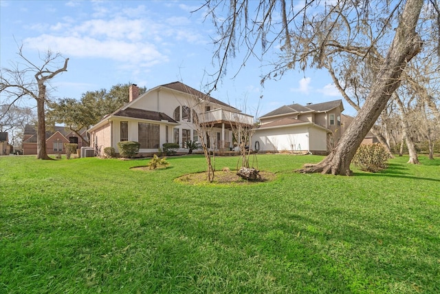 rear view of house featuring a wooden deck and a yard