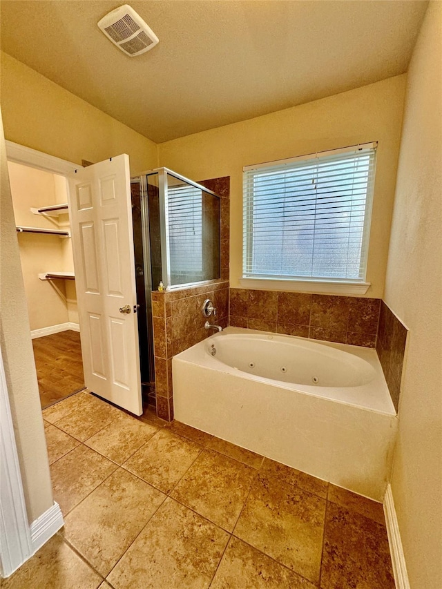 bathroom featuring plus walk in shower and tile patterned flooring