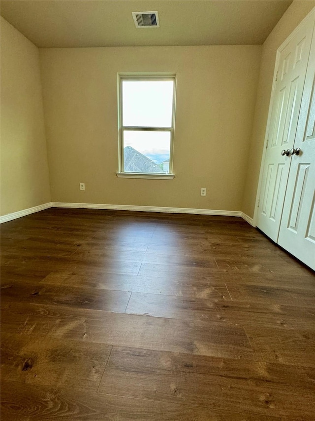 unfurnished bedroom with dark hardwood / wood-style flooring