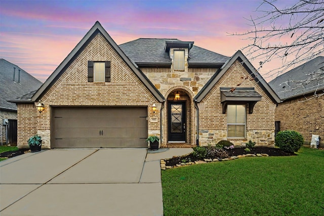 view of front of house with a garage and a lawn