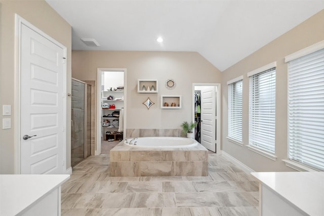 bathroom featuring vanity, shower with separate bathtub, and vaulted ceiling