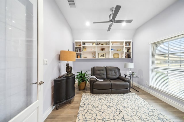 living area with ceiling fan and light hardwood / wood-style flooring