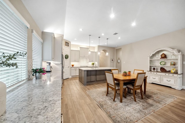 dining room with sink and light hardwood / wood-style flooring