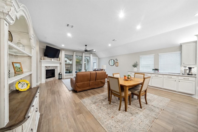 dining space with vaulted ceiling, a wealth of natural light, ceiling fan, and light hardwood / wood-style floors