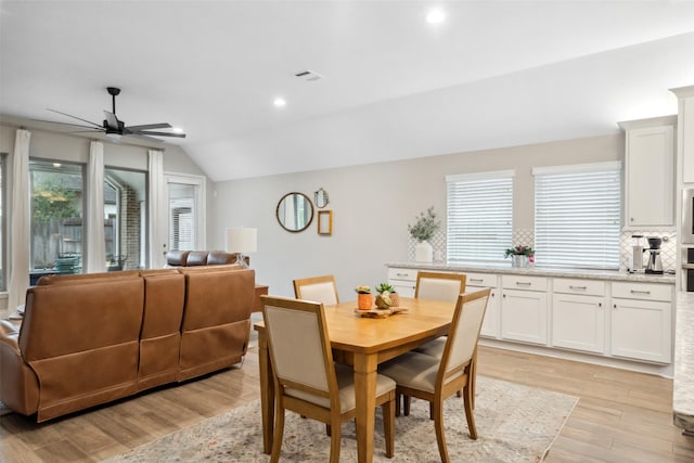 dining area with light hardwood / wood-style flooring, vaulted ceiling, and ceiling fan