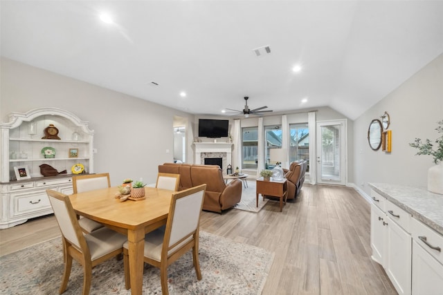 dining room with lofted ceiling, ceiling fan, and light wood-type flooring