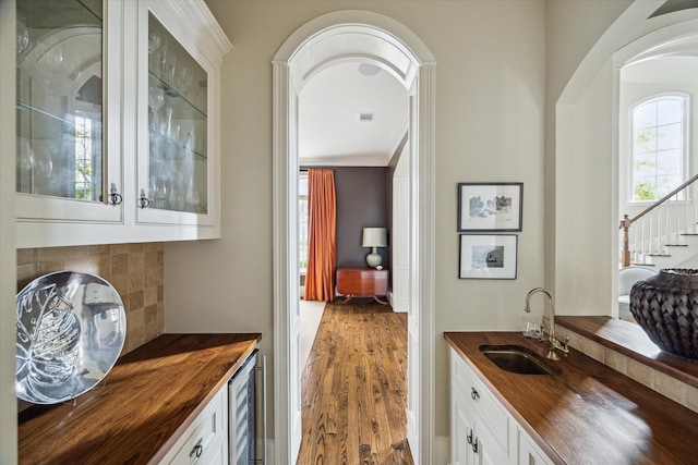 bar featuring white cabinetry, sink, wine cooler, and butcher block counters