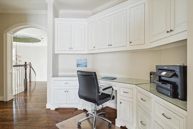 home office with dark hardwood / wood-style flooring, built in desk, and ornamental molding