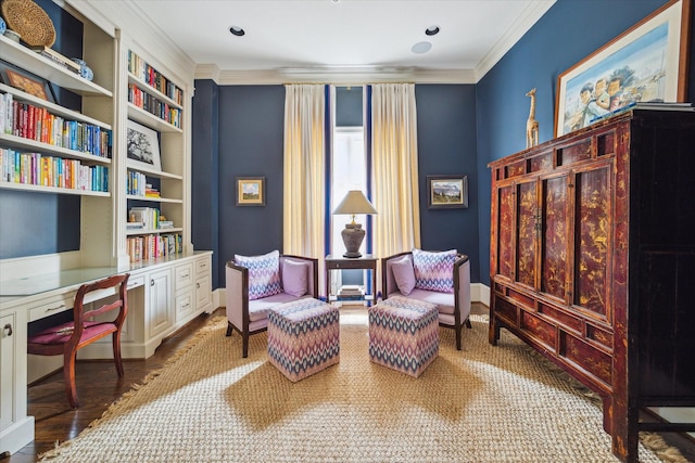 sitting room featuring ornamental molding and built in desk