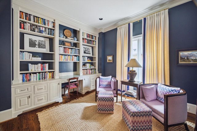 living area with ornamental molding, dark hardwood / wood-style floors, and built in desk