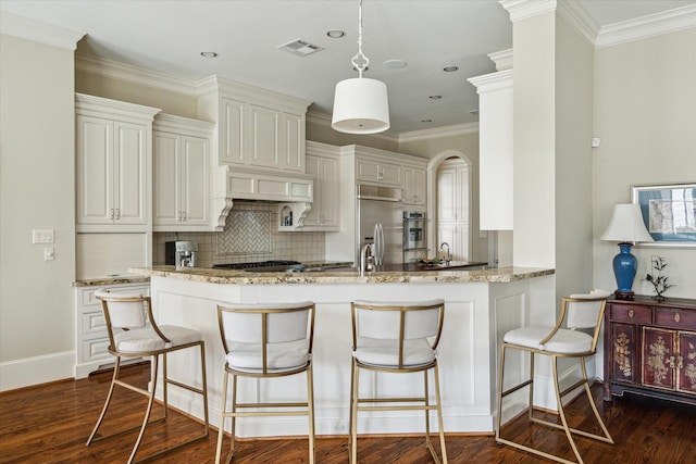 kitchen featuring dark wood-type flooring, premium range hood, light stone countertops, kitchen peninsula, and built in fridge