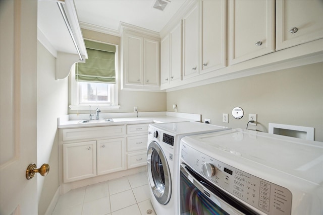 laundry area featuring cabinets, washer and clothes dryer, sink, and light tile patterned floors