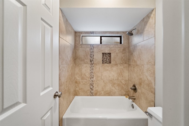 bathroom featuring tiled shower / bath combo and toilet