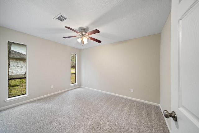 carpeted spare room with ceiling fan and a textured ceiling