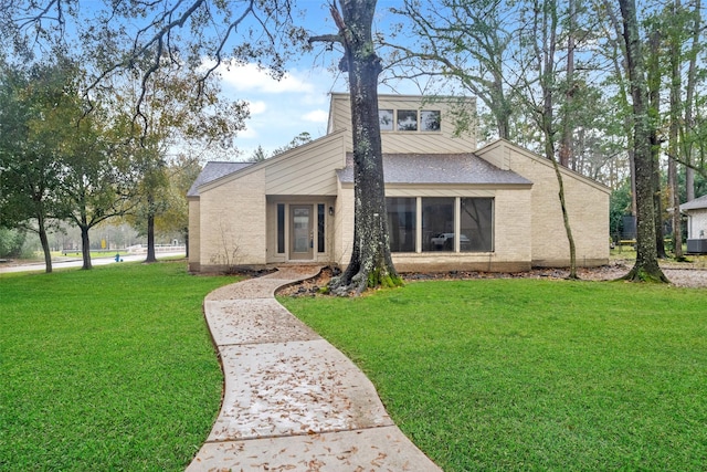 view of front facade featuring central AC unit and a front lawn