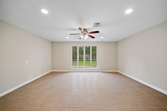 empty room with light tile patterned floors, a textured ceiling, and ceiling fan