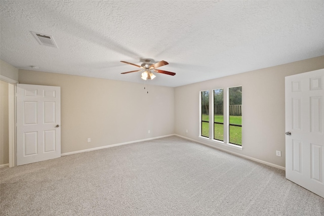 carpeted spare room featuring a textured ceiling and ceiling fan