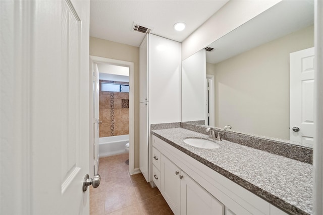 full bathroom with tile patterned floors, vanity, toilet, and tiled shower / bath combo