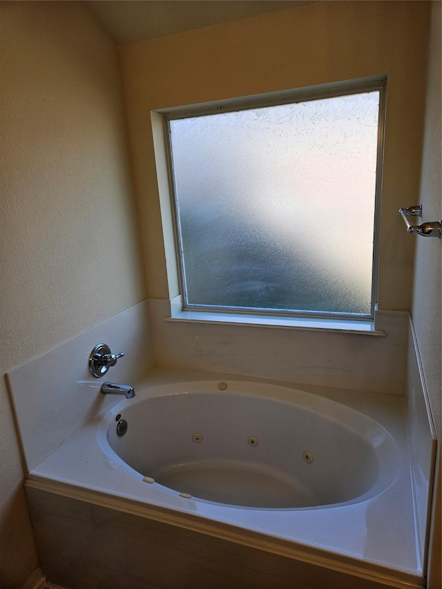 bathroom with a relaxing tiled tub