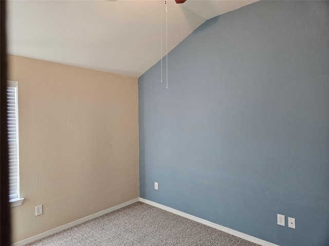 carpeted spare room featuring ceiling fan and vaulted ceiling