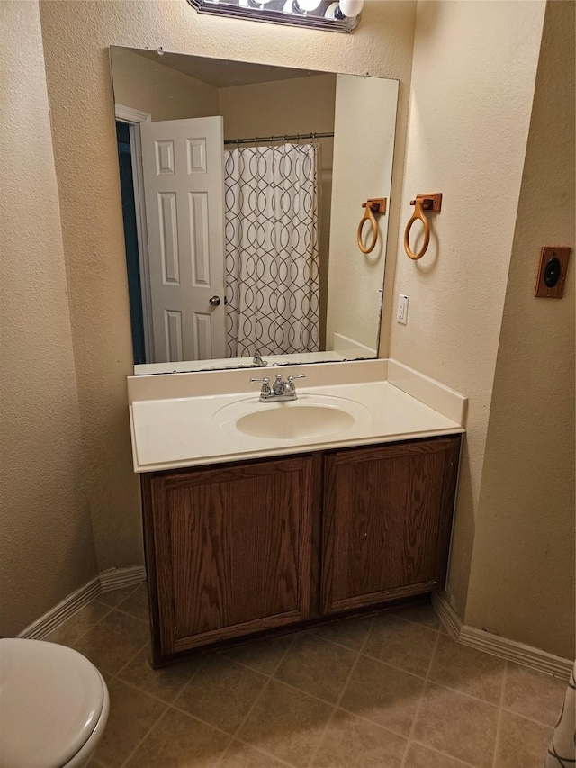 bathroom featuring tile patterned floors, vanity, and toilet