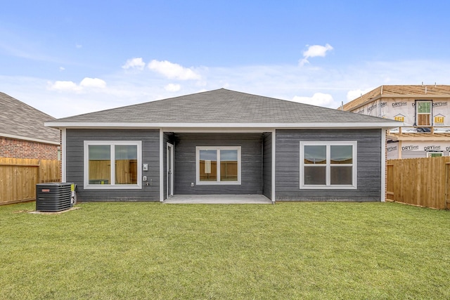 rear view of house with central AC, a yard, and a patio area