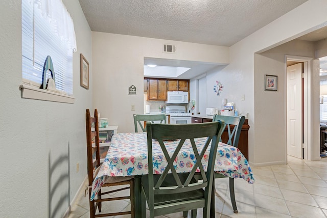 tiled dining room with a textured ceiling