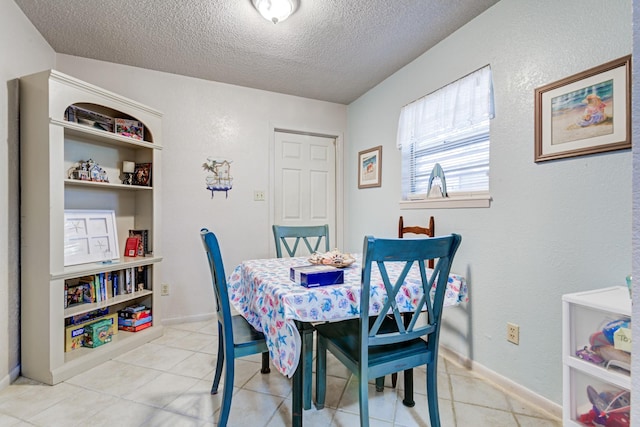 dining room featuring a textured ceiling and light tile patterned floors