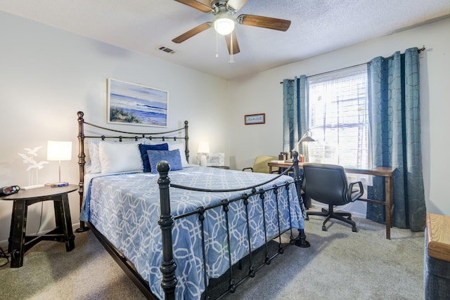 carpeted bedroom with ceiling fan and a textured ceiling