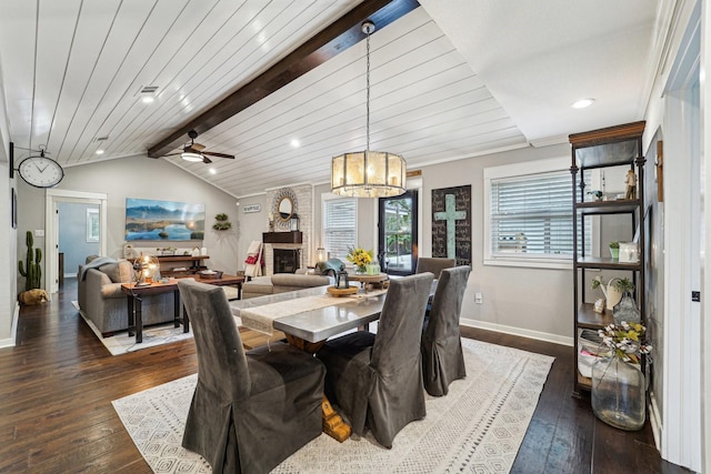 dining space featuring wood ceiling, dark wood-type flooring, a fireplace, and lofted ceiling with beams