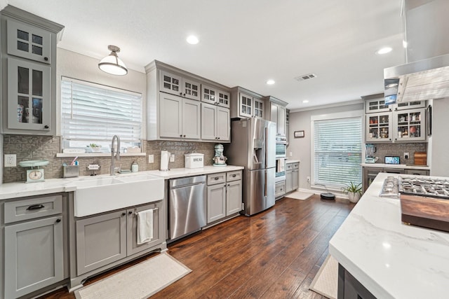 kitchen featuring dark wood-type flooring, sink, crown molding, appliances with stainless steel finishes, and gray cabinets