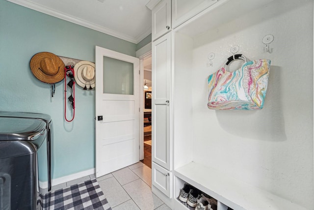 clothes washing area featuring light tile patterned flooring, washing machine and clothes dryer, and crown molding