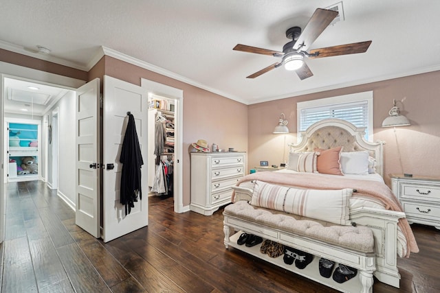 bedroom with a walk in closet, ornamental molding, and dark hardwood / wood-style floors