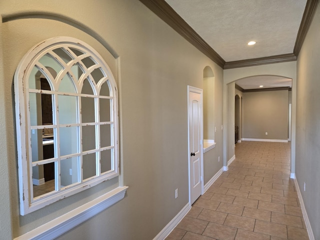 hall featuring ornamental molding, light tile patterned floors, and a textured ceiling