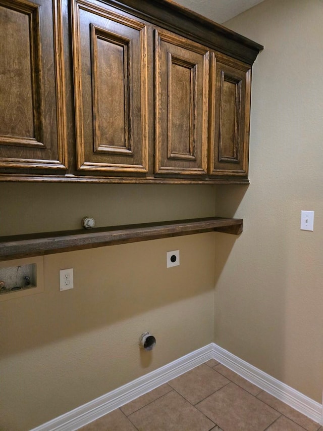 clothes washing area with light tile patterned floors, hookup for a washing machine, cabinets, and hookup for an electric dryer