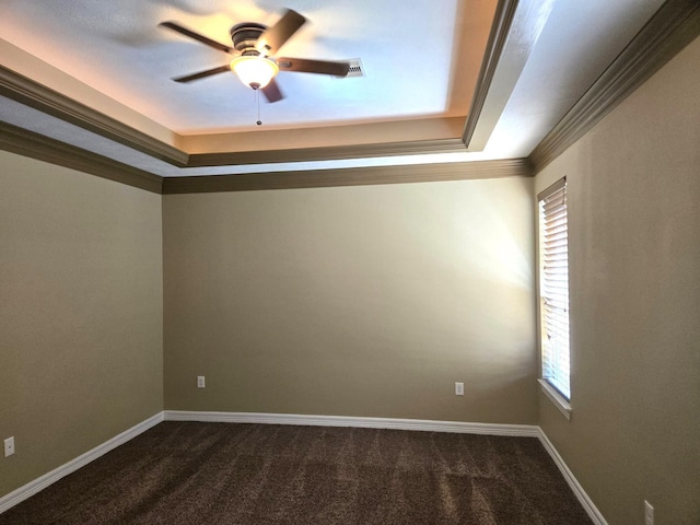 unfurnished room with a tray ceiling, dark carpet, ornamental molding, and ceiling fan