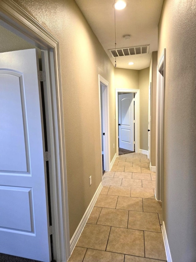 hall with light tile patterned floors