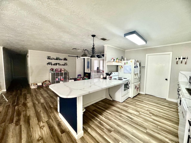 kitchen featuring a kitchen bar, white cabinetry, hardwood / wood-style flooring, pendant lighting, and white appliances