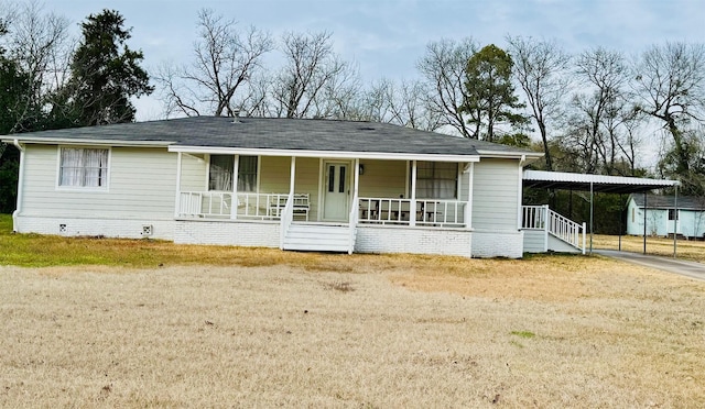 view of front of property featuring a carport, a front yard, and covered porch