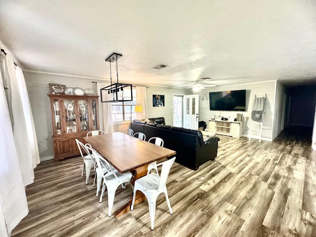 dining space with hardwood / wood-style floors, a textured ceiling, and ceiling fan