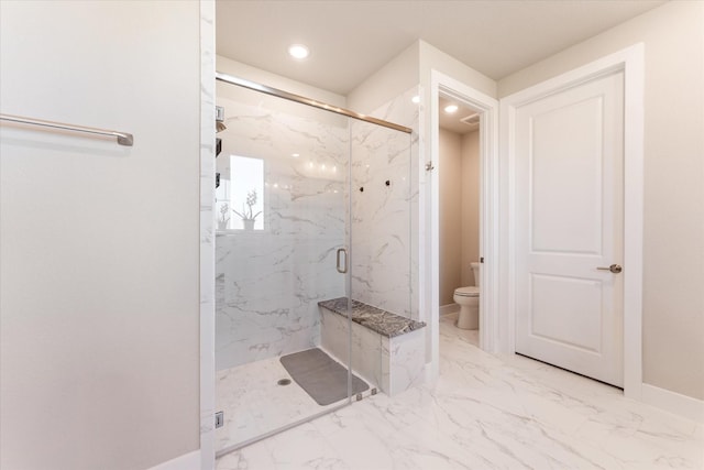 bathroom with a shower with door and toilet