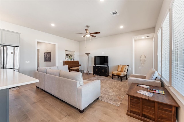 living room with ceiling fan and light hardwood / wood-style flooring