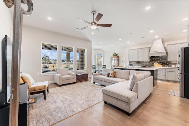 living room with ceiling fan and light wood-type flooring