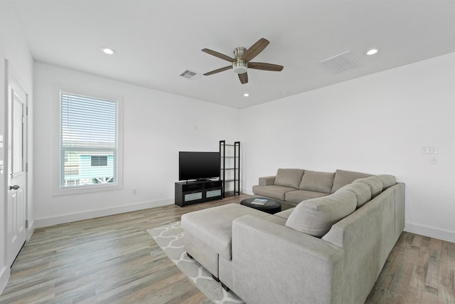 living room with ceiling fan and light hardwood / wood-style flooring